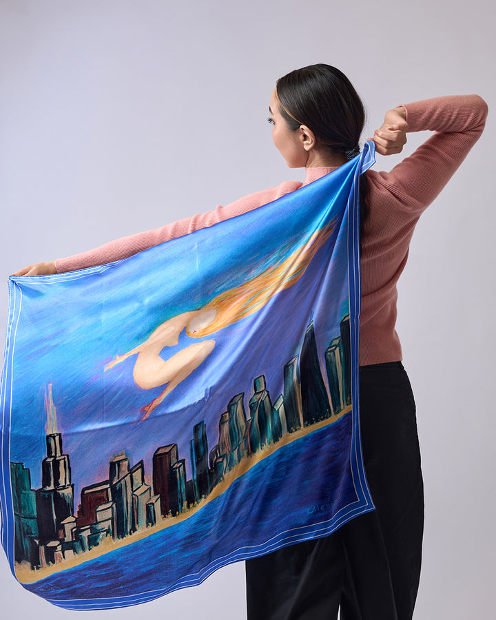 Midnight Muse pure silk scarf by Alesia Chaika, featuring a hand-painted golden muse flying over the Chicago skyline and Lake Michigan in deep blue tones. AlesiaC.com